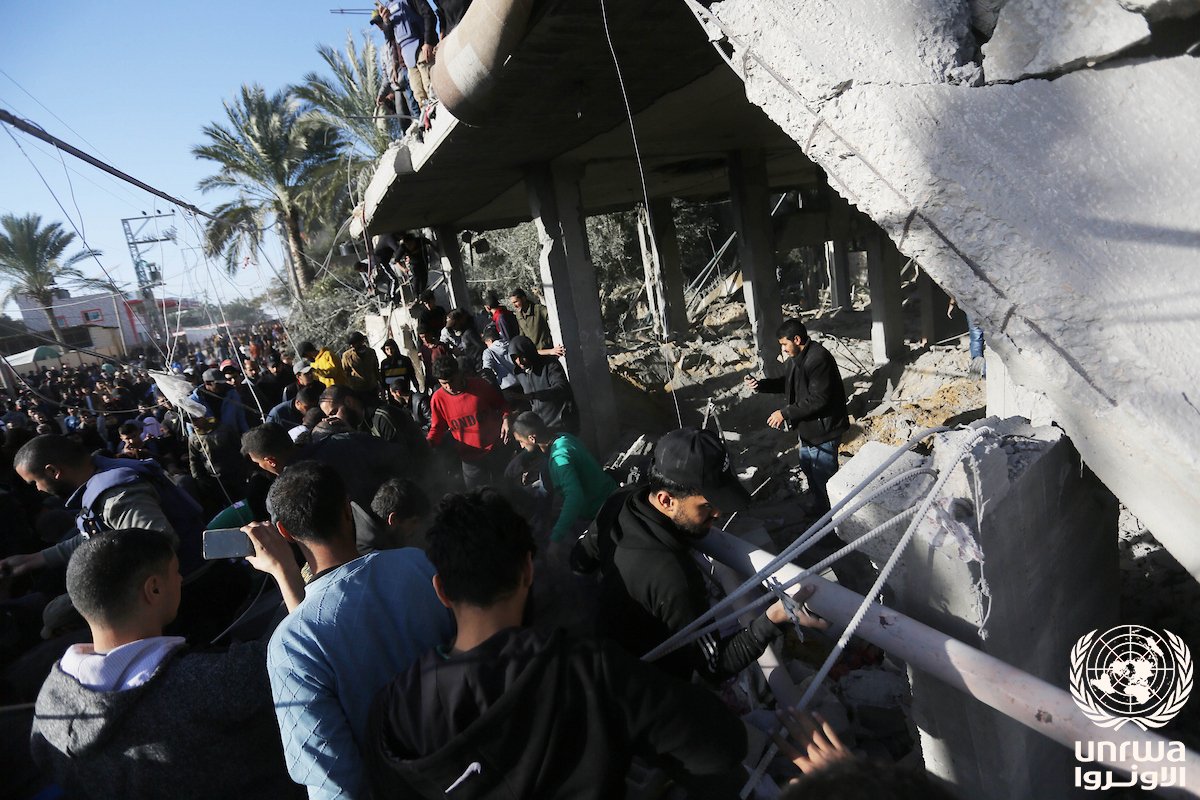 Palestiniens fouillant les décombres d'un immeuble détruit à Deir el-Balah, dans la bande de Gaza